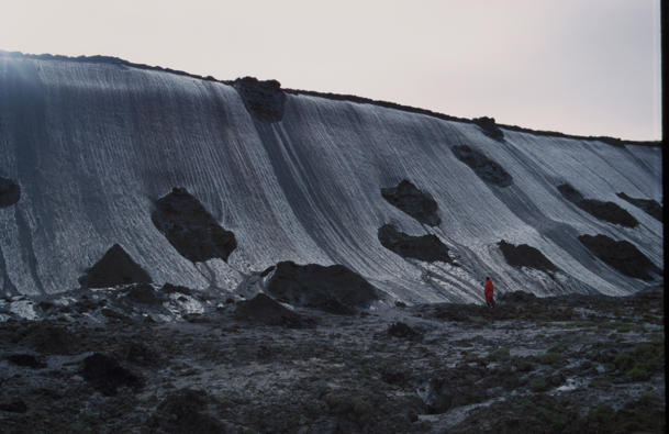 Check out this ice-rich Yedoma permafrost with huge ice wedges. The ground ice forms a massive ice wall on the coast of the Dmitri-Laptev-Strait in NE Siberia. Person for scale! Image by Guido Grosse.