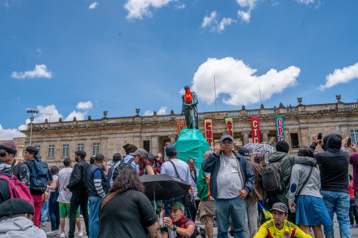 BenjaminNorton's tweet photo. A communist at the May Day protest today in Bogotá climbed the statue of Simon Bolívar in Plaza Bolívar, the historical and political heart of the capital, and put a hammer-and-sickle bandana on the Great Liberator. https://t.co/IHdyDs2eCl