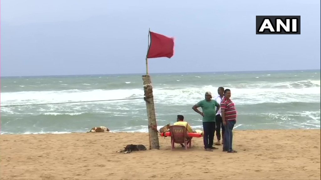 ANI's tweet photo. Odisha: People at Puri beach being warned against venturing into the sea as #CycloneFani is expected to make landfall in Puri district tomorrow. https://t.co/HJXGhbFwQl