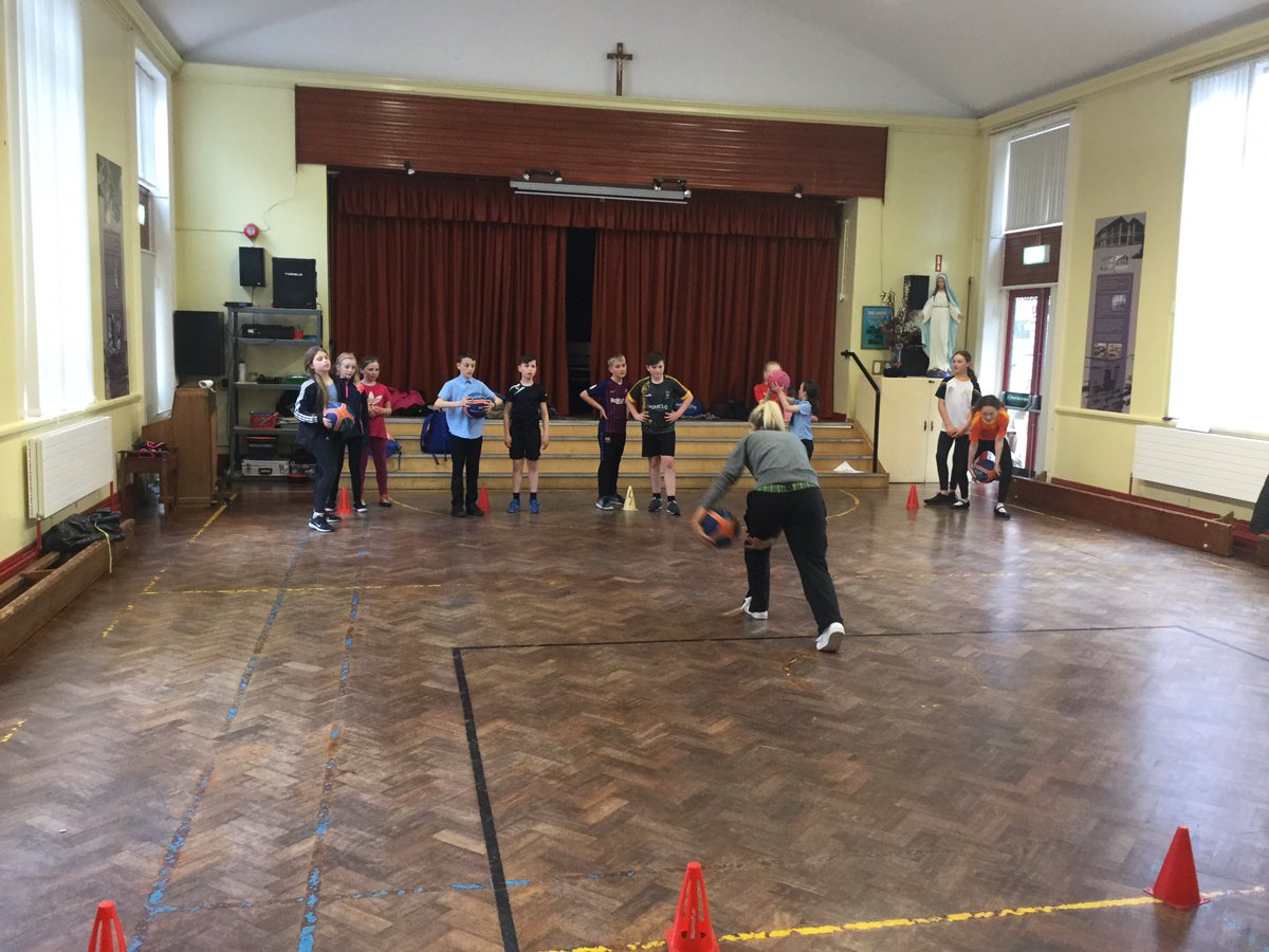 Miss Rafferty instructs KS2 children in the after school basketball club.