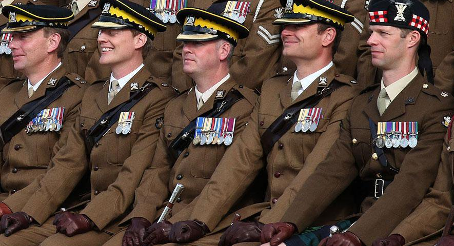 Five middle age white males, all in uniform. One of them has a kilt.
