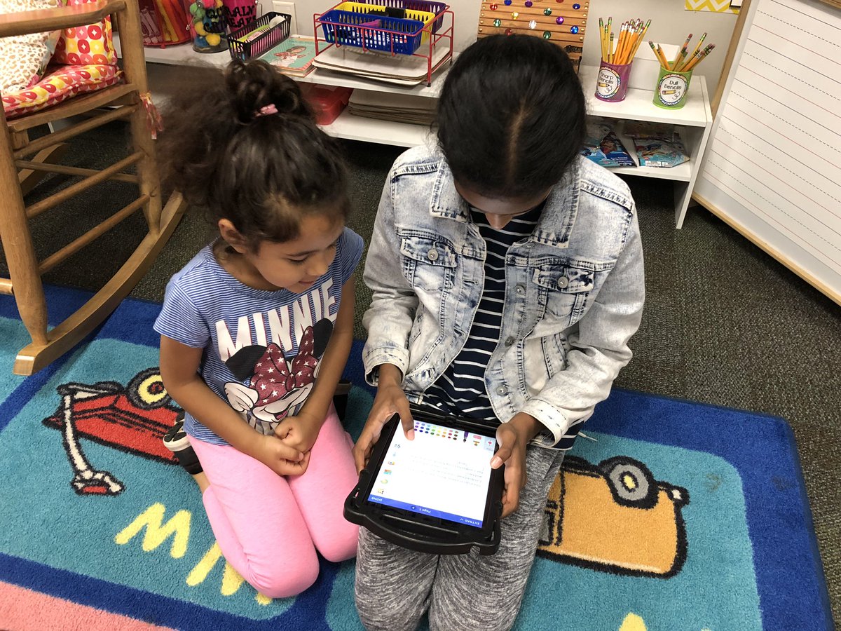 Kinder and 5th grade buddies working on writing a book together.