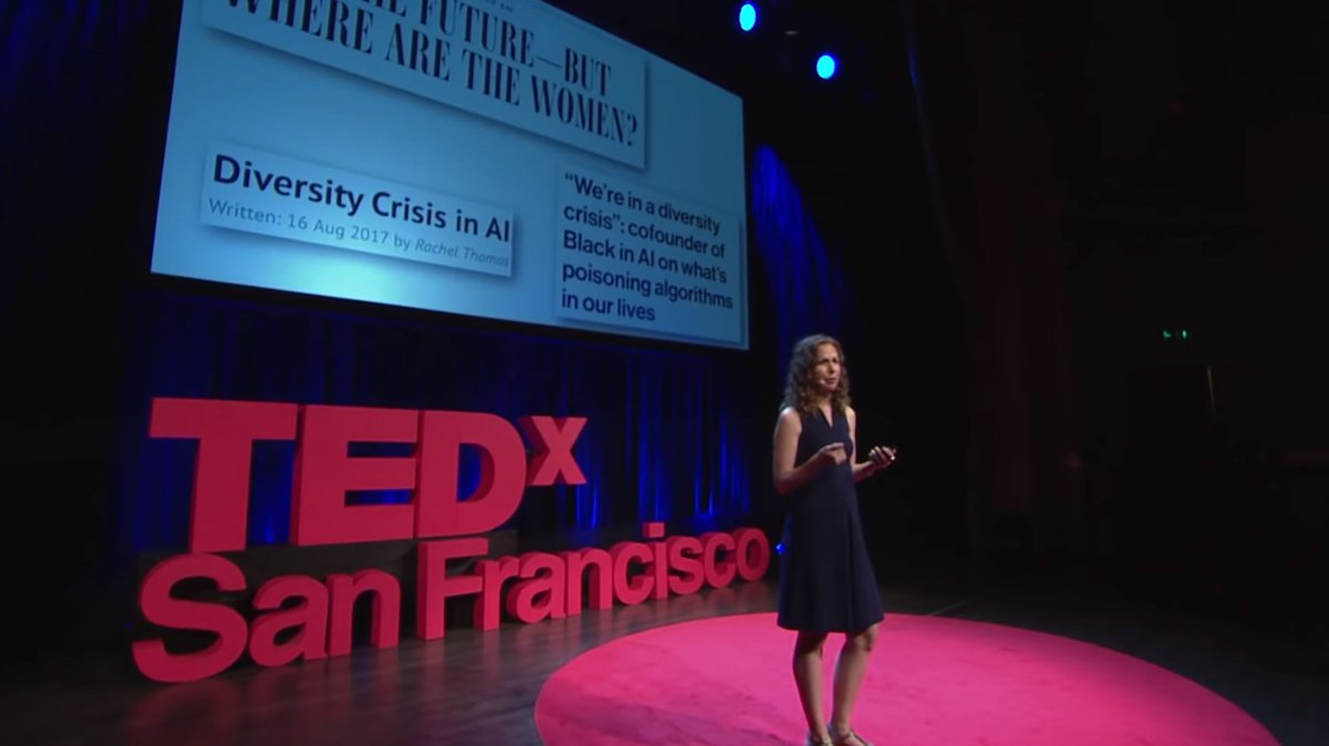 Me standing on stage, in front of a slide that has the headlines: "'We're in a diversity crisis': cofounder of Black in AI on what's poisoning algorithms in our lives.", "Diversity crisis in AI" and "AI is the future- but where are the women?"