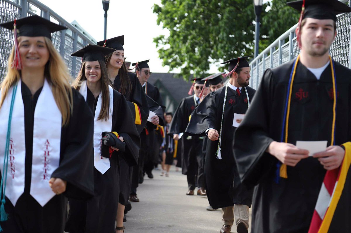 sjuhawknews's tweet photo. The procession continues as the class of 2019 walks across McShain Bridge to Curran Field where the ceremony will take place #HawkHillGrad19 https://t.co/78gpUwjPPQ