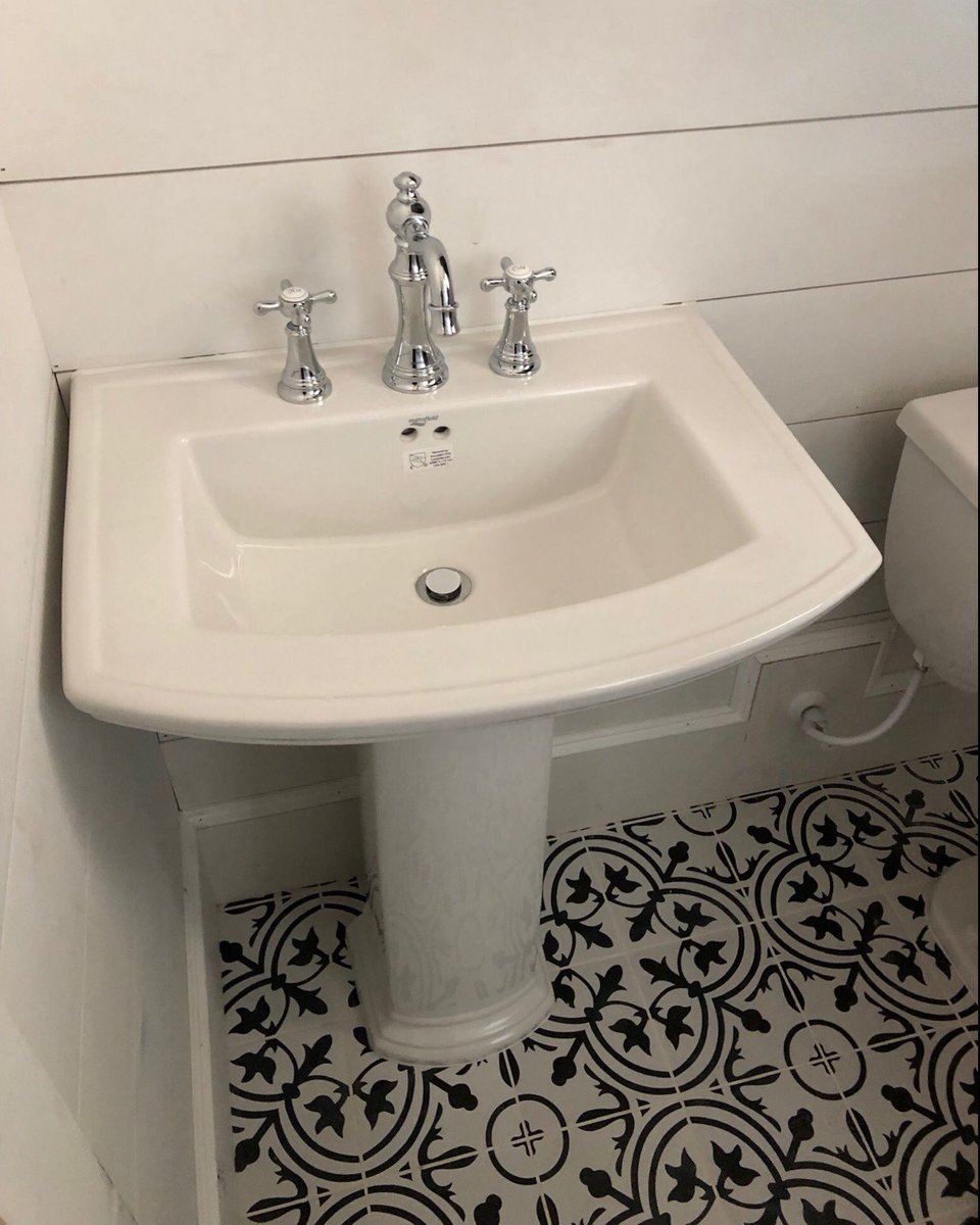 Vintage-inspired bathrooms are trending right now. This one features a pedestal sink, chrome fixtures and black & white patterned tile to complete the look. 🖤 #VintageBathroom #CustomHome