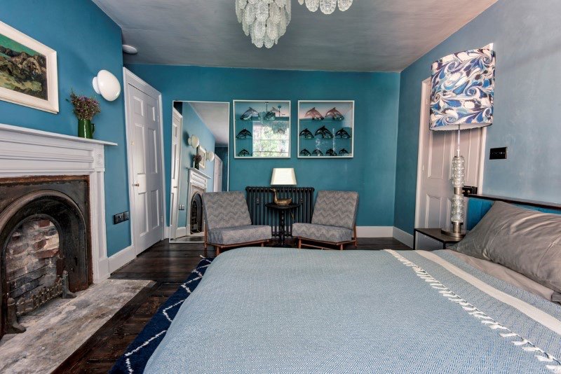 A king size double bedroom illuminated by 20th-century chandelier lighting provides a fairy tale view of a unique living wall trailing with fern and ivy. The mirror ball shower room sits adjacent to this room. #interiordesign #interiorsunday #Hastings