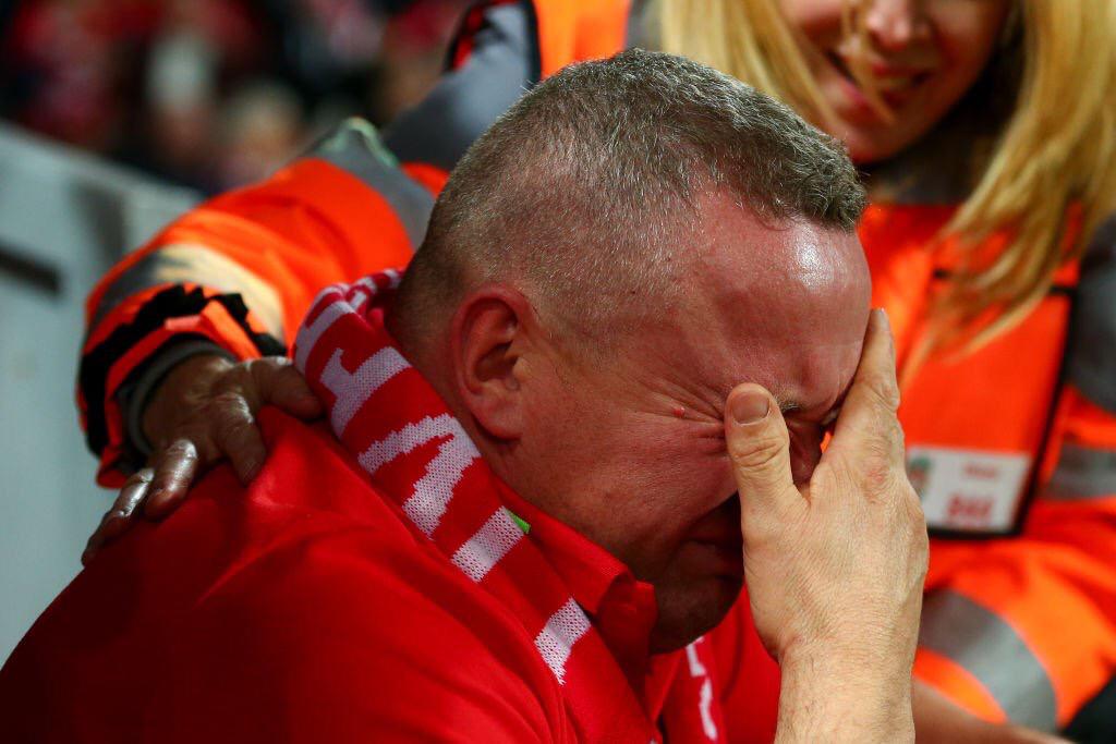 TyCSports's tweet image. Y algunos dicen que solo es fútbol: veintidós personas que corren detrás de una pelota. Sí, claro, tal vez suceda en otro planeta. El hincha de Liverpool rompe en llanto en pleno Anfield, una mujer de seguridad lo asiste. ¡Cuántas emociones! ¡Aguante, corazón, aguante!