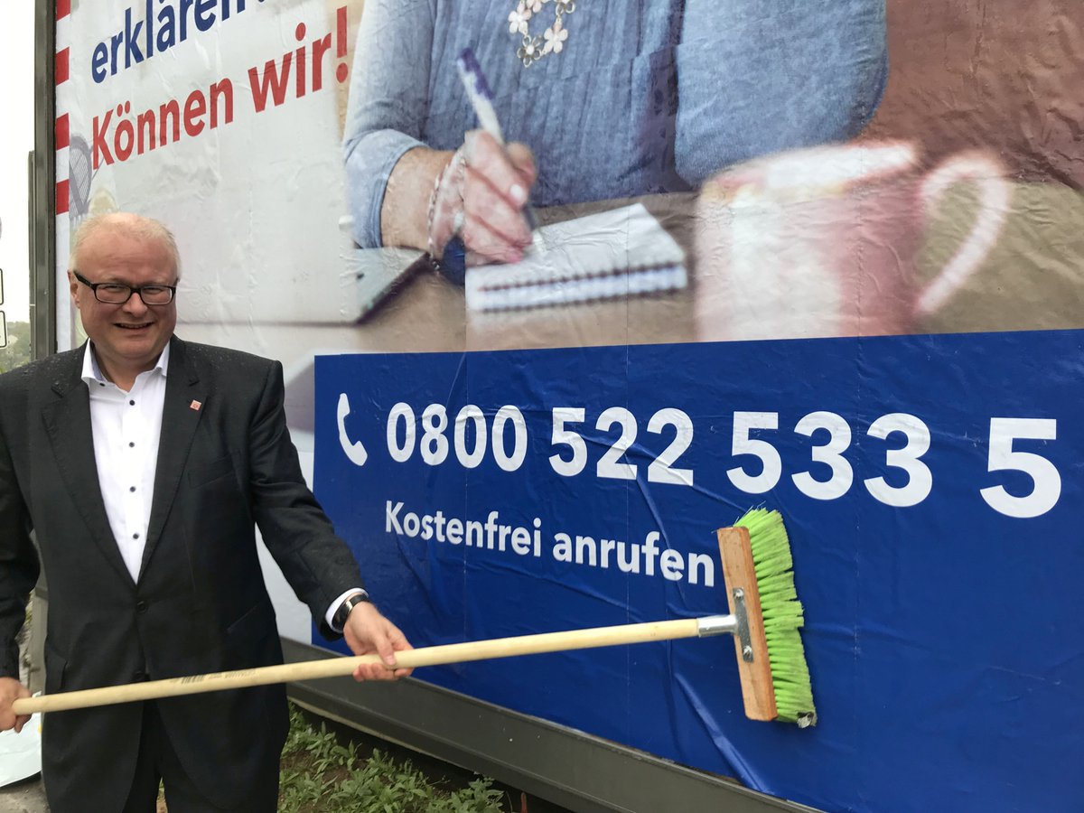 FinanzenHessen's tweet photo. Steht heute im Regen, weil wir unsere BürgerInnen bei #Steuerfragen nicht im Regen stehen lassen: @schaeferhessen klebt Plakate für die neue kostenlose #Servicenummer für allg. Fragen #Steuern: 0800 522 533 5. Infos gibt's auch unter https://t.co/bYZAI5KZhC. #HLT #ChefmachtSachen https://t.co/jO4TltI3J3