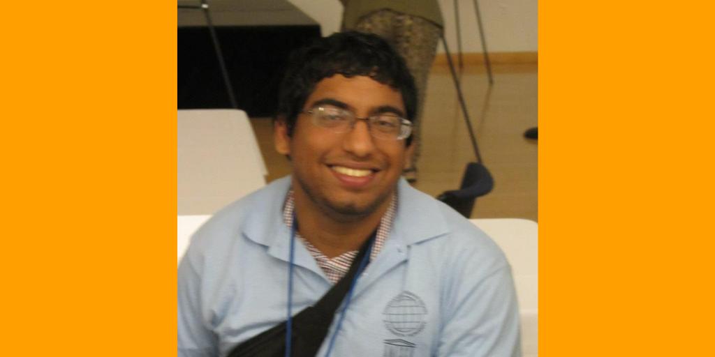 Orange background with a photo of Hamza Jaka, a brown American Pakistani man, smiles up at the camera. He is wearing glasses, a blue UNESCO Chair Institute shirt, and a fanny pack along with lanyard.