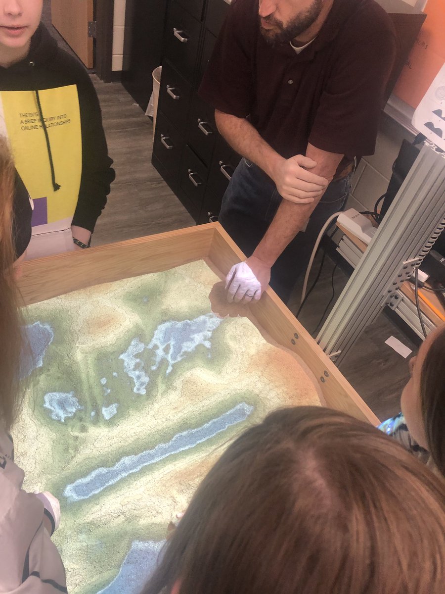 DorisAHerrmann's tweet image. Check out our @BulldogsBsi 8th graders on science learning about topography with our #ARSandbox. #scientist.