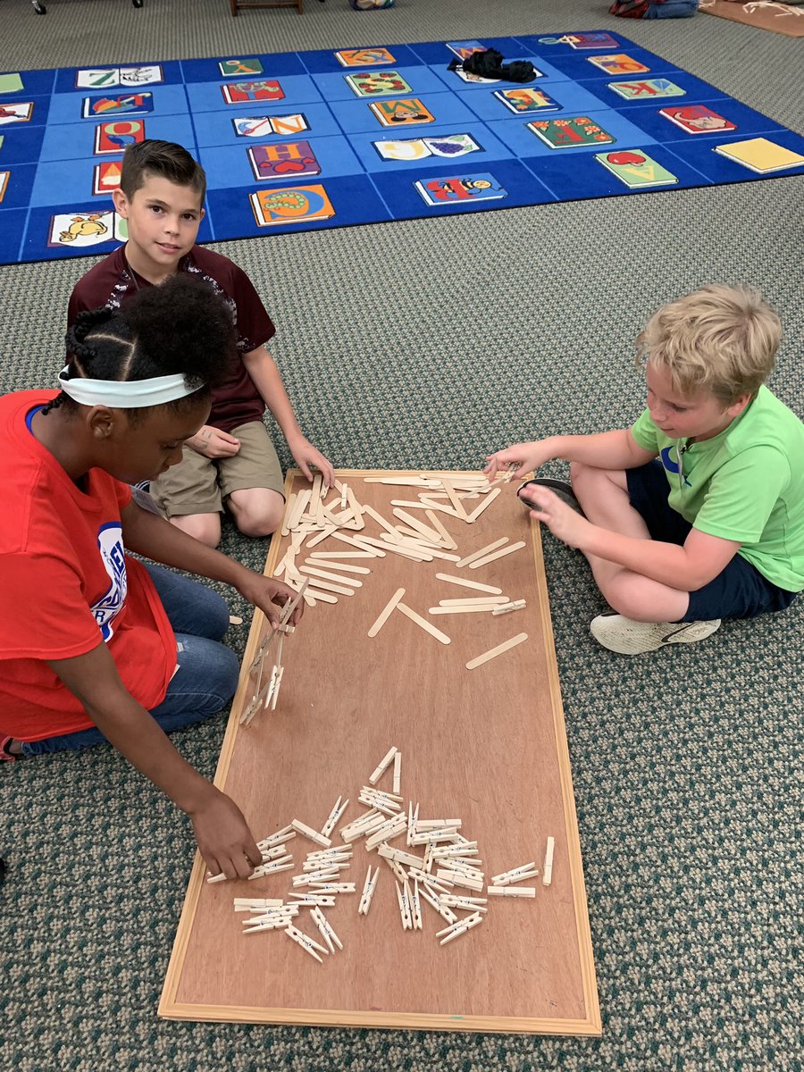 Students building bridges in the library! How many books will the bridges hold?