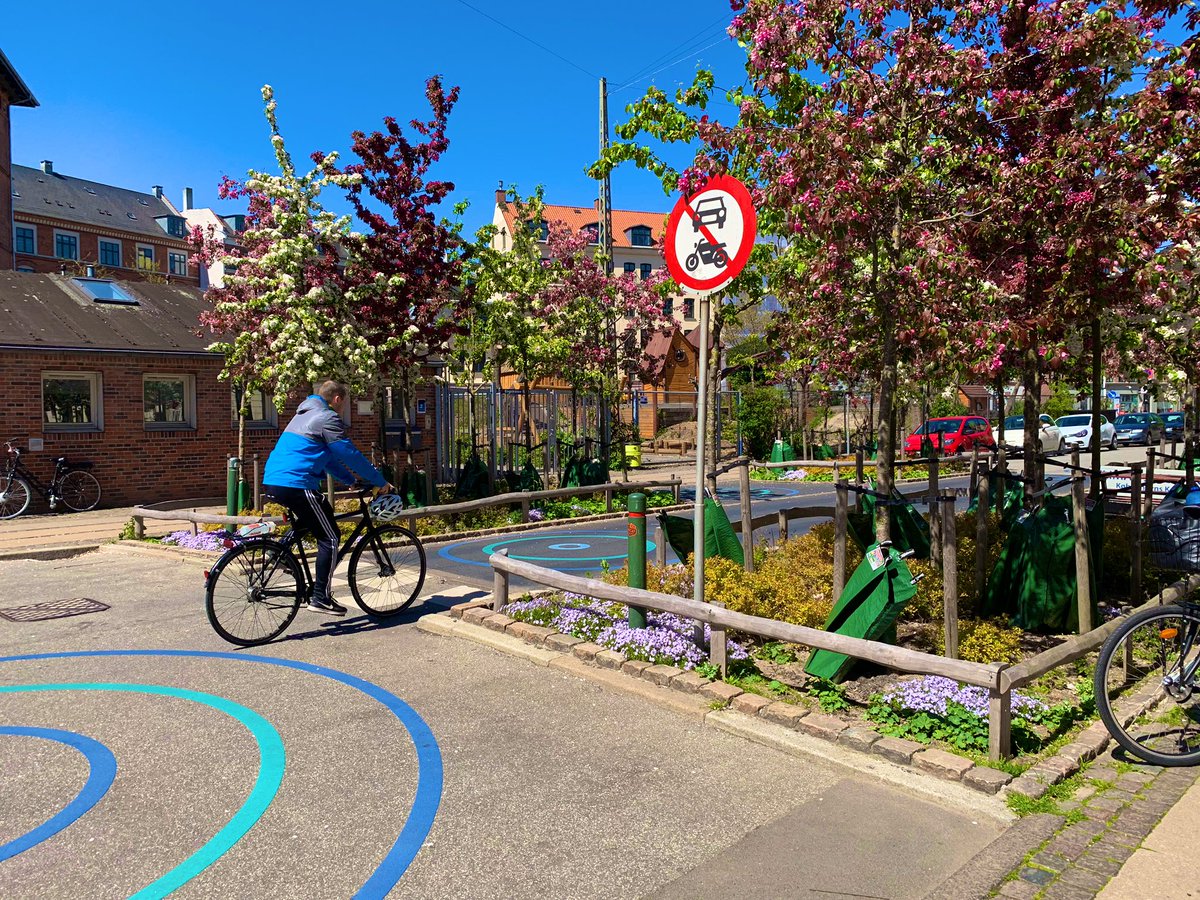 This pinch point & deadend street 
= 
Reduced car speeds, safer crossing, a playground, gorgeous trees/ landscape, fun patterns, & a place for a dad with a sleeping baby to rest at a picnic table.  

#streetsforkids #safespeeds #roadsafety #gobalstreets