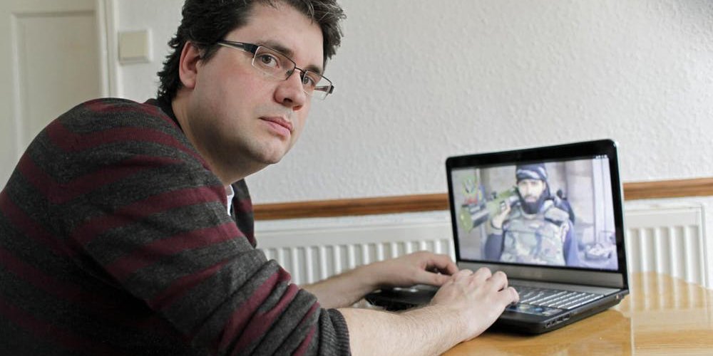 Eliot Higgins poses for a photograph in front of his laptop.
