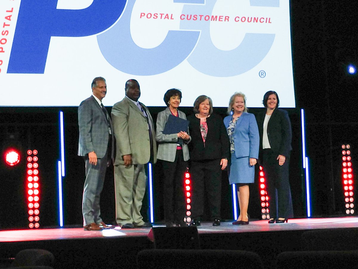 The_Alt_Mailing's tweet photo. It's #FlashbackFriday and we're going back to October to the 2018 Carolina Postal Forum! Our own Nancy Jones accepted the Gold &amp; Platinum level awards on behalf of the #GTAPCC and posed for this excellent photo with the Postmaster General, Megan Brennan. #alternativemailing #USPS https://t.co/SFvLcZi3Bb