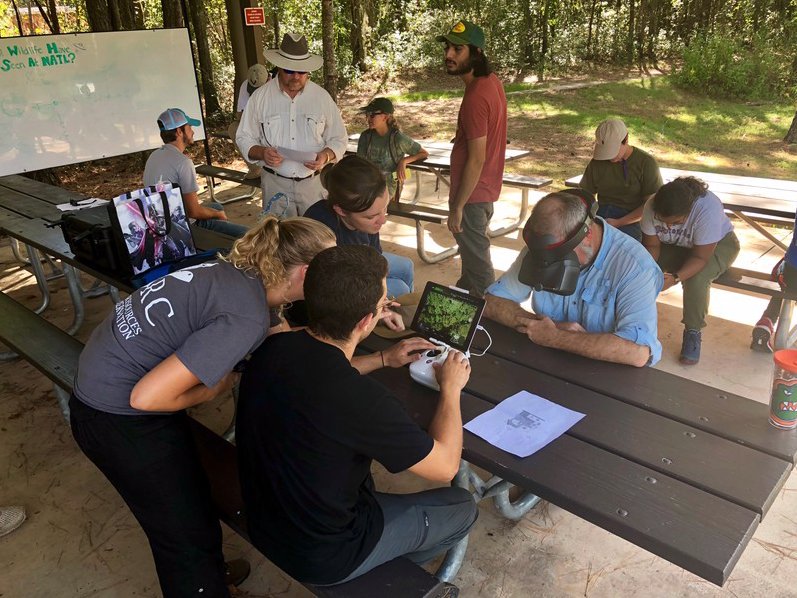 SFFGS_UF's tweet photo. #TBT! Scott Sager (goggles) teams up with SFRC student Cesar Zamora (pilot) in a field lab using drones to monitor tree health in his undergraduate Natural Resources Sampling course. Thanks Dr. @ebennb and SPEC Lab for making this activity possible! #SPECLab #Geomatics #Drones https://t.co/Ofmhu2jqvx