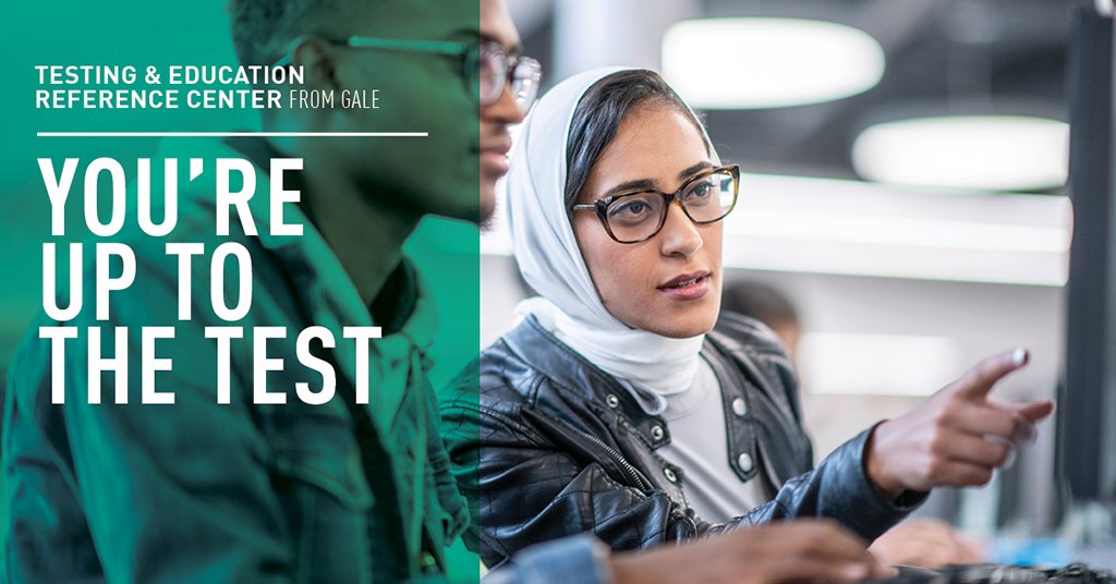 a woman wearing a headscarf pointing at a computer screen while a smiling man looks on