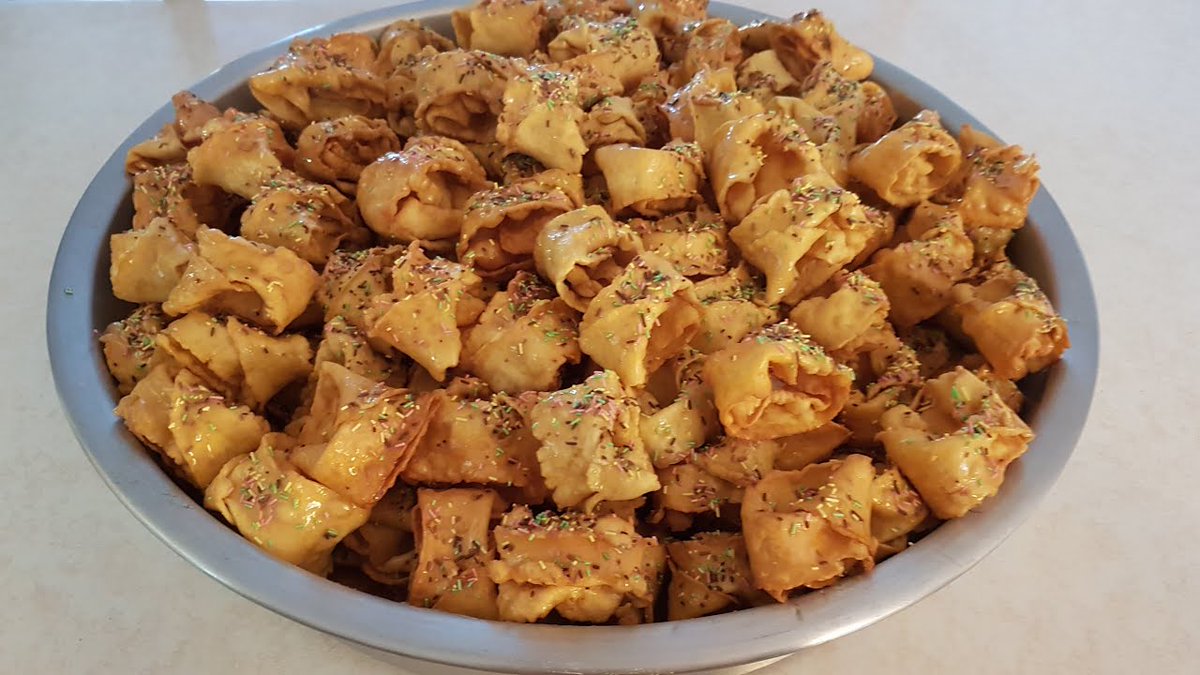 OUDNIN EL KADHISignifie les oreilles du Juge. réparée à base de farine, d'œufs, d’huile, d'eau de fleur d'oranger ou d’eau, de sucre vanillé et de sel, puis étalée et découpée en bandes. Placées dans l’huile et enroulées autour d'une fourchette, égouttées et sucrées avec du miel