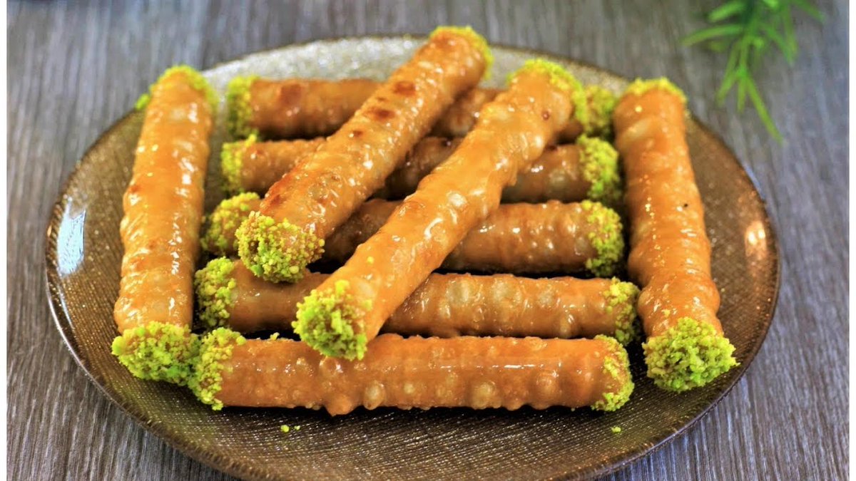 BOUREK RENNALe bourek renna est une pâtisserie traditionnelle Originaire d'Annaba, à base de feuille de brick, fourrée avec une farce d'amande, de noix de coco et de cannelle. Cette pâtisserie, en forme de cigare, est enrobée de miel après friture.