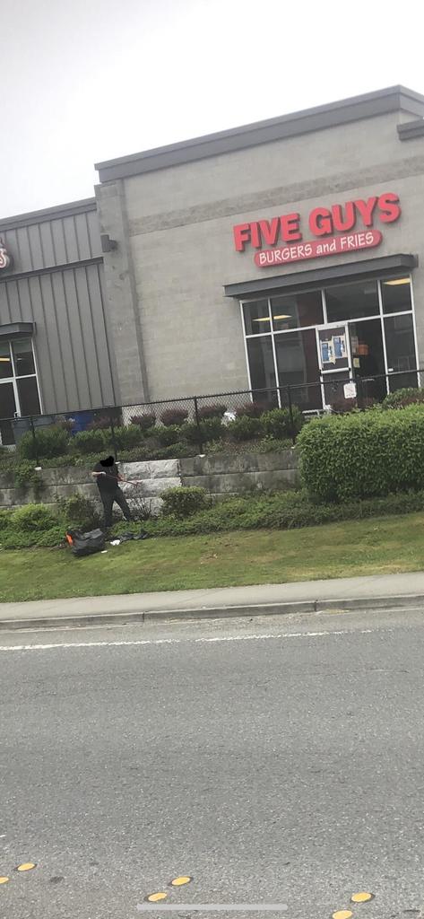 I drove past the Five Guys where the oil was being dumped from the pic yesterday and saw this man cleaning the mess up this morning.