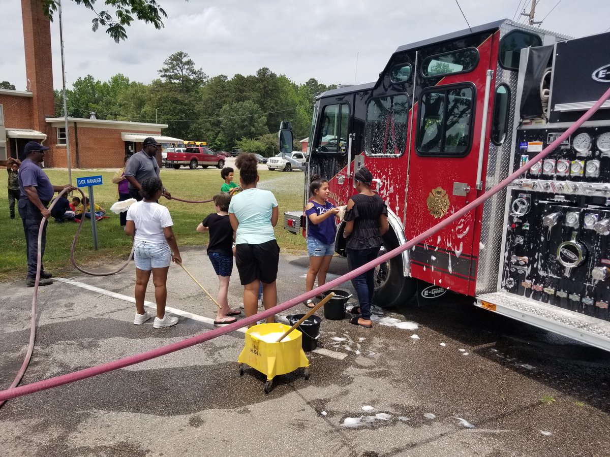 Deputy Chief Travis Richardson  and  Chief Daren Small provide Deyjon with some additional hose.