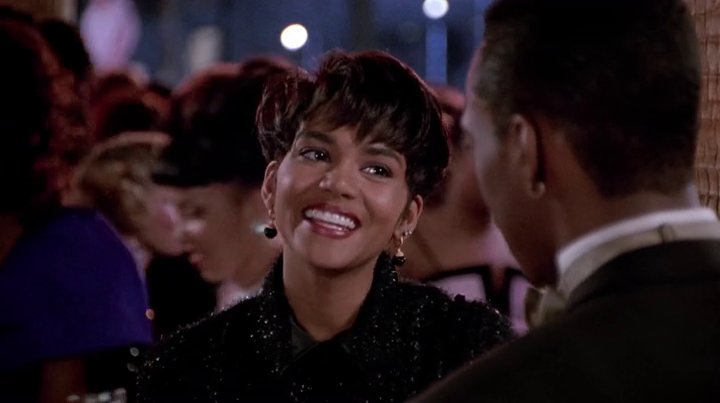 The sweet-natured Angela Lewis (played by a then relatively unknown Halle Berry) has a comforting and charming sense of style. Her favorite accessory is her winning smile. It's interesting to see Halle before she became one of Hollywood's biggest bombshells of all-time.