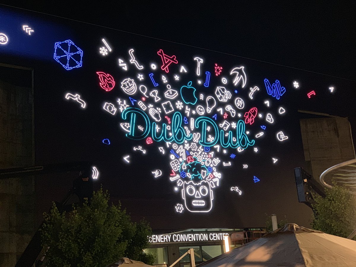 The front of the WWDC 19 convention hall lit up in neon.