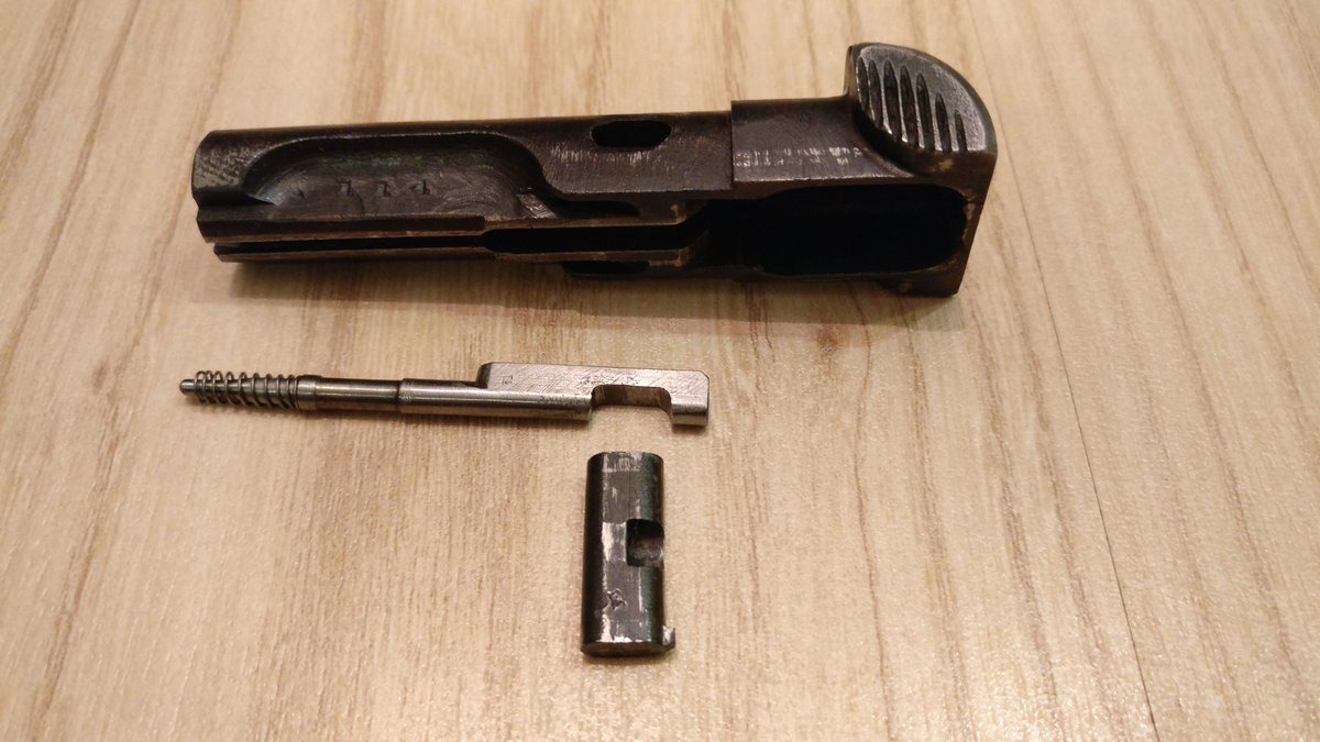 The disassembly of the slide features a cross-bolt type block held in place with the firing pin in the two consecutive pictures one can see the firing pin protruding and locking in the cross-bolt.