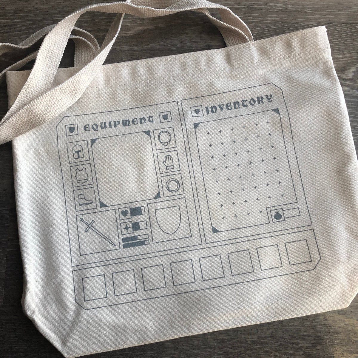 Next is a screen printed tote bag designed for displaying pins! A divider sewn into the bag protects the pin backs from the rest of the bag's contents. Made with recycled canvas, measures 14x12' (conveniently the perfect size for tabletop books.) emilycheeseman.myshopify.com/products/equip…