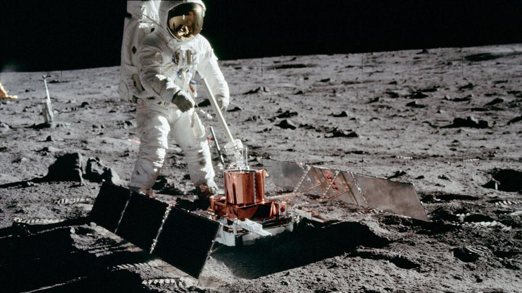An astronaut conducts a seismic experiment on the surface of the Moon.