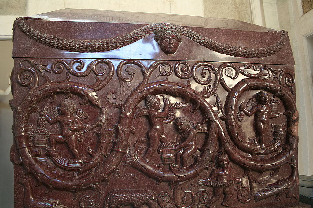 SokolowskiLuk's tweet photo. Red Porphyry Sarcophagus of #Constantina, #VaticanMuseums, originally located in #SantaConstanza. The decoration is a semi-pagan depiction of cupids in #Dionysic harvesting of grapes surrounded by #vine_scroll. Interpreted as an early Christian reference to the Eucharist. https://t.co/wypNIrAxQ6