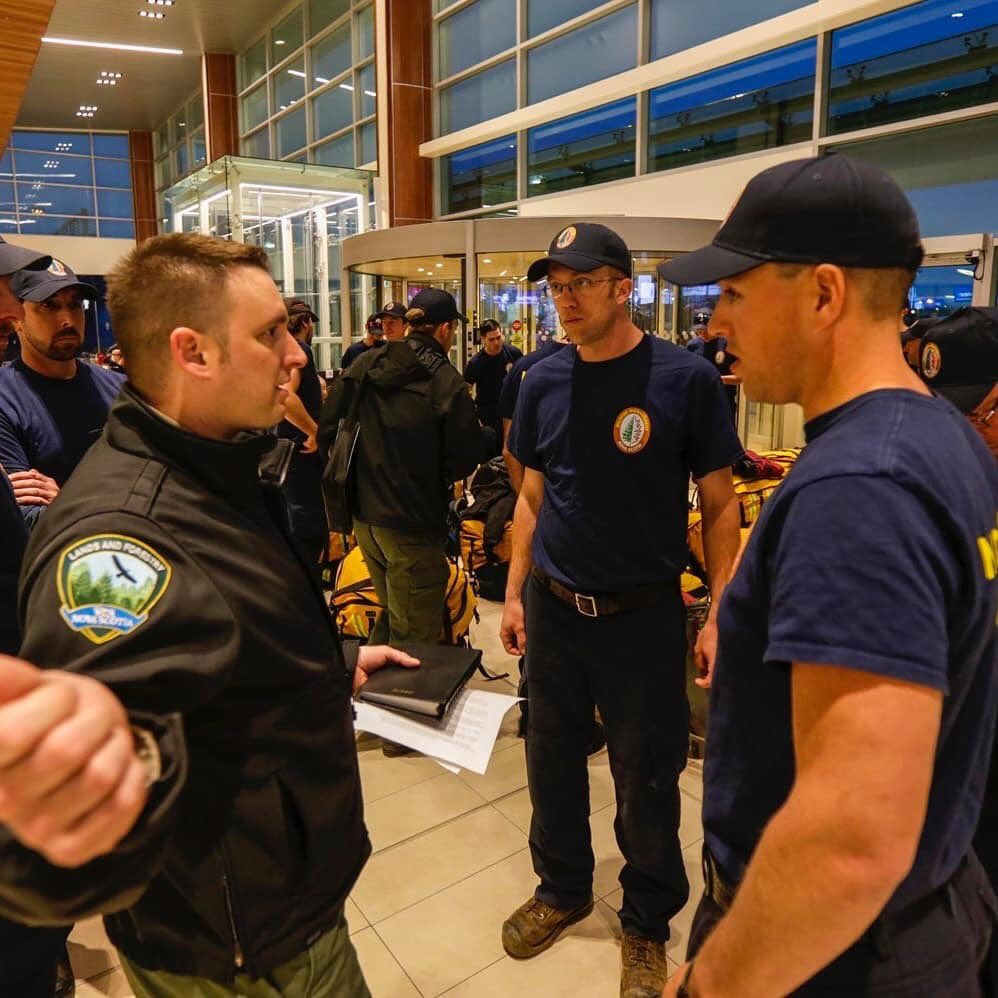 StephenMcNeil's tweet photo. A crew of 21 brave men and women left Nova Scotia this morning to help fight wildfires in #Alberta. The wildfire crew is expected to be on the fireline for about two weeks. On behalf of all Nova Scotians, we thank you for your service and look forward to your safe return. #ABfire https://t.co/yzpMuF7e8X