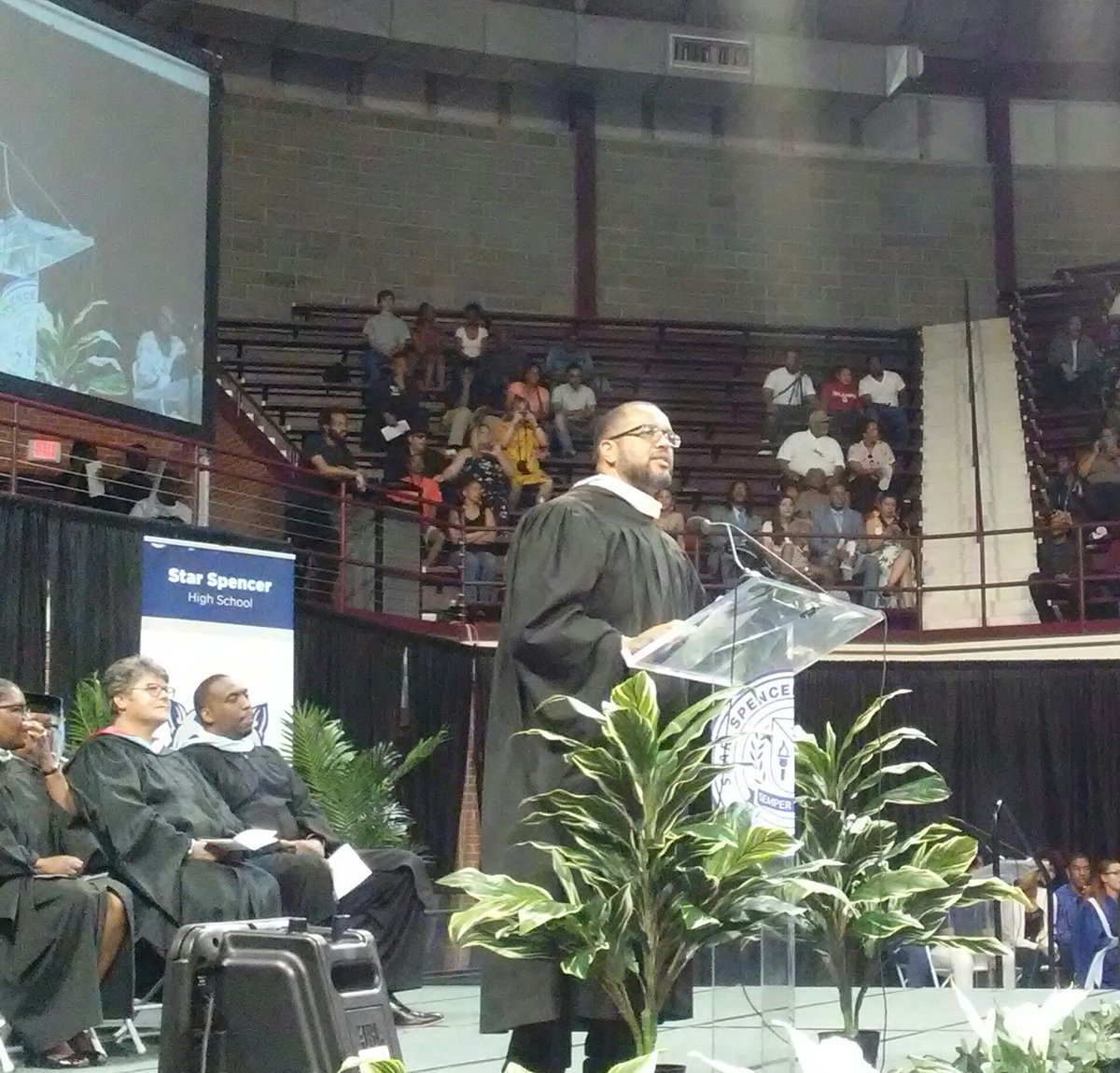 OKCPS's tweet photo. Assistant Superintendent Jason Brown taking a moment to recognize the parents, family members, mentors, community members that supported their students in this journey! It takes a village!! 🎓🙌 @starspencerhs 
#okcpsgraduation https://t.co/7QyNmQWlh7