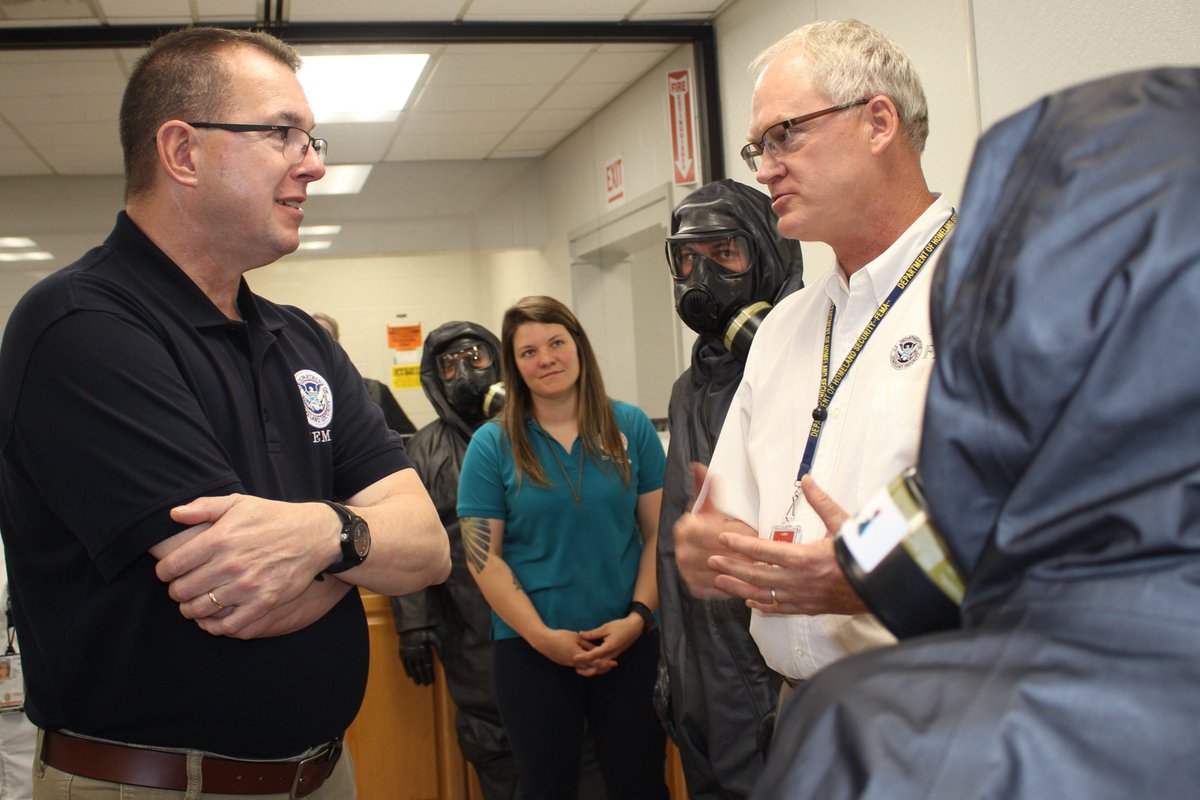 Acting FEMA Administrator Pete Gaynor talks to employees at CDP.  He is speaking directly to one while four individuals stand around them.  Three of those individuals are wearing face masks.