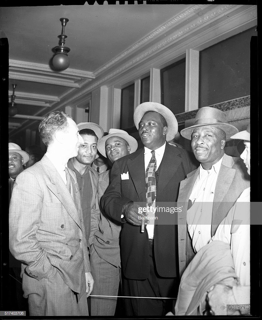 Harry Bridges is shown with a group of his longshoremen outside of Federal Court just before Bridges went on trial during the Red Scare.