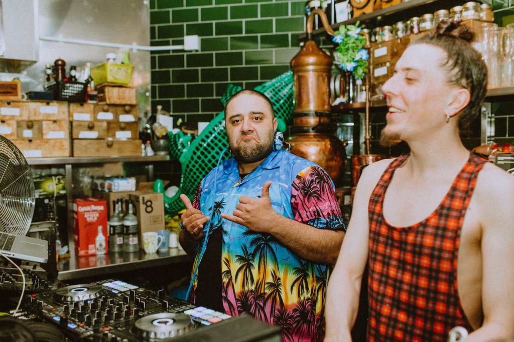 The extremes of the human physique.⁣
⁣
On the right, we have the best bar back/vegan rapper aka MISTA ILL (don’t ask) in the business. ⁣
⁣
On the left is a gyros slinging, track spinning, shirt splitting sun of a gun DJ TAV.⁣