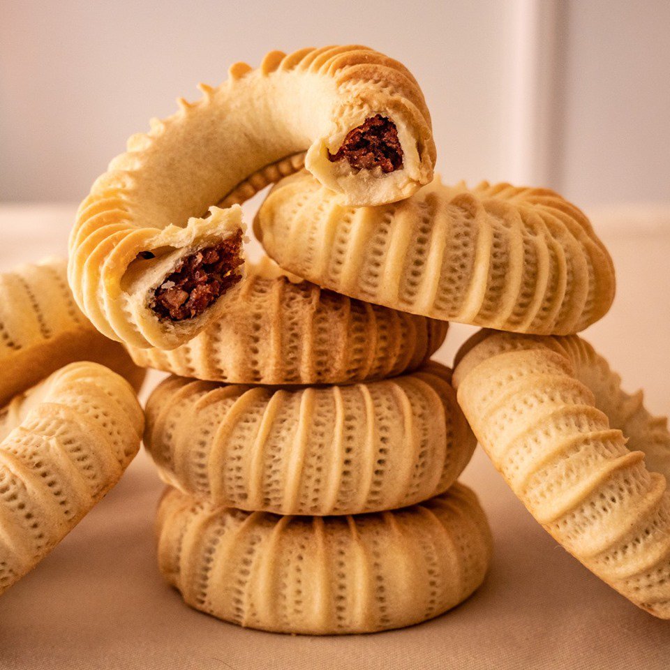KAAK EL NEKKACHECette pâtisserie algérienne consiste en une pâte façonnée pour former un bracelet et farcie avec une pâte de dattes. Originaire de Bejaia, les kaaks de l'Oranie et Tlemcen sont parfumé avec du fenouil, de l'anis et des graines de sésame, sans la farce de dattes.