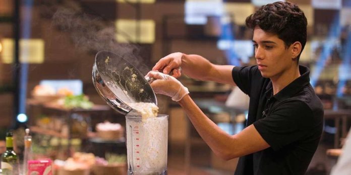 Eliminação de Helton do MasterChef revolta a internet uol.page.link/u5dFN #PraCegoVer #PraTodosVerem: Foto de Helton Oliveira preparando uma sopa vichyssoise. Ele tem cabelos pretos e curtos, veste uma camisa polo preta e despeja comida de uma panela ao liquidificador