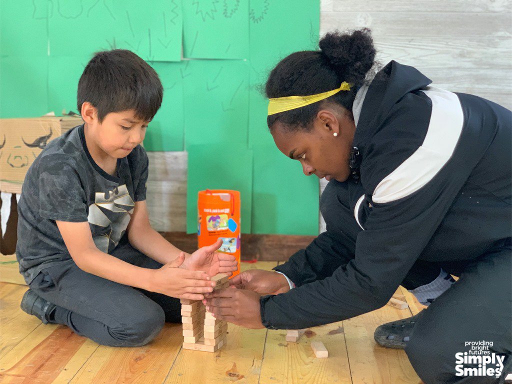 RegisCollege_MA's tweet photo. A team from Regis is in South Dakota working w/ children from @simplysmilesinc which creates environments to support children and families in need. Slated for the super hero themed week is cape and mask making and a basketball clinic. #RegisService FMI: https://t.co/yBVrWzKkai https://t.co/sdwxsVIwPa