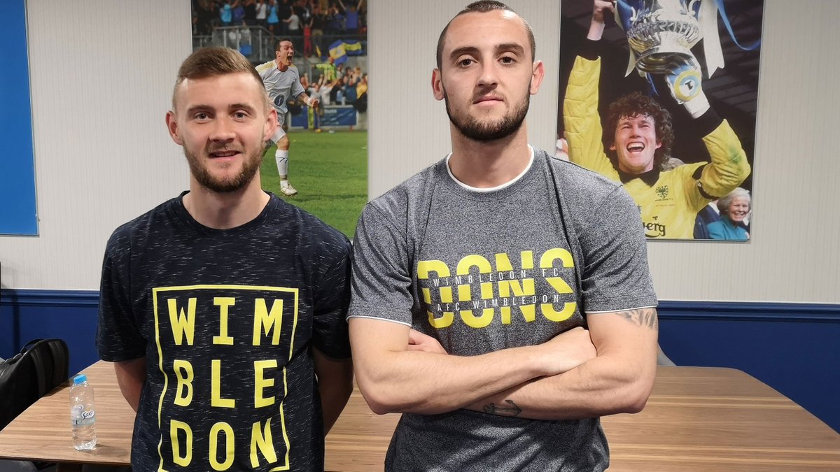 AFCWimbledon's tweet image. Brand-new Summer tees...it’s a 👍 from this Dons duo 🍀

👉 | Dons t-shirt (£20) bit.ly/2YLnBXU  
👉 | Wimbledon t-shirt (£20) bit.ly/30Q2m9s  

#WeAreWimbledon | #COYD