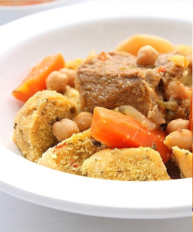 TIKOURBABINECe mets est originaire de Kabylie se compose de boulettes de semoule, de forme ronde ou ovale, cuites dans une sauce rouge piquante, parfumée à la coriandre et à la menthe. préparées avec de la semoule de blé ou d’orge, d'huile, d'oignons et d'épices, un peu de sauce