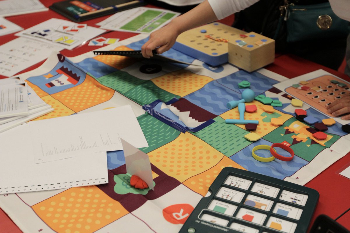 A table filled with colourful adapted coding materials and tools.