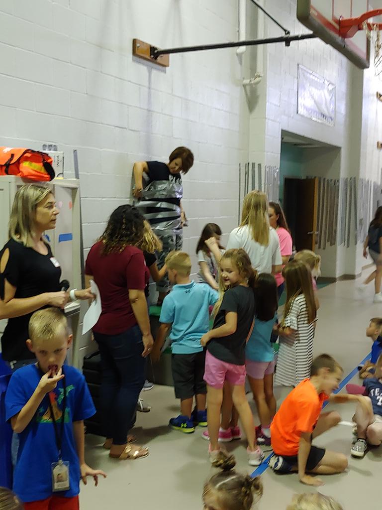 CaptainCoody's tweet photo. My principal, Shannon Thompson, gets duct taped to the wall by students that donated boxtops. @MtPeak_Elem #misdproud #misdhappy https://t.co/jgkUwIG0gj