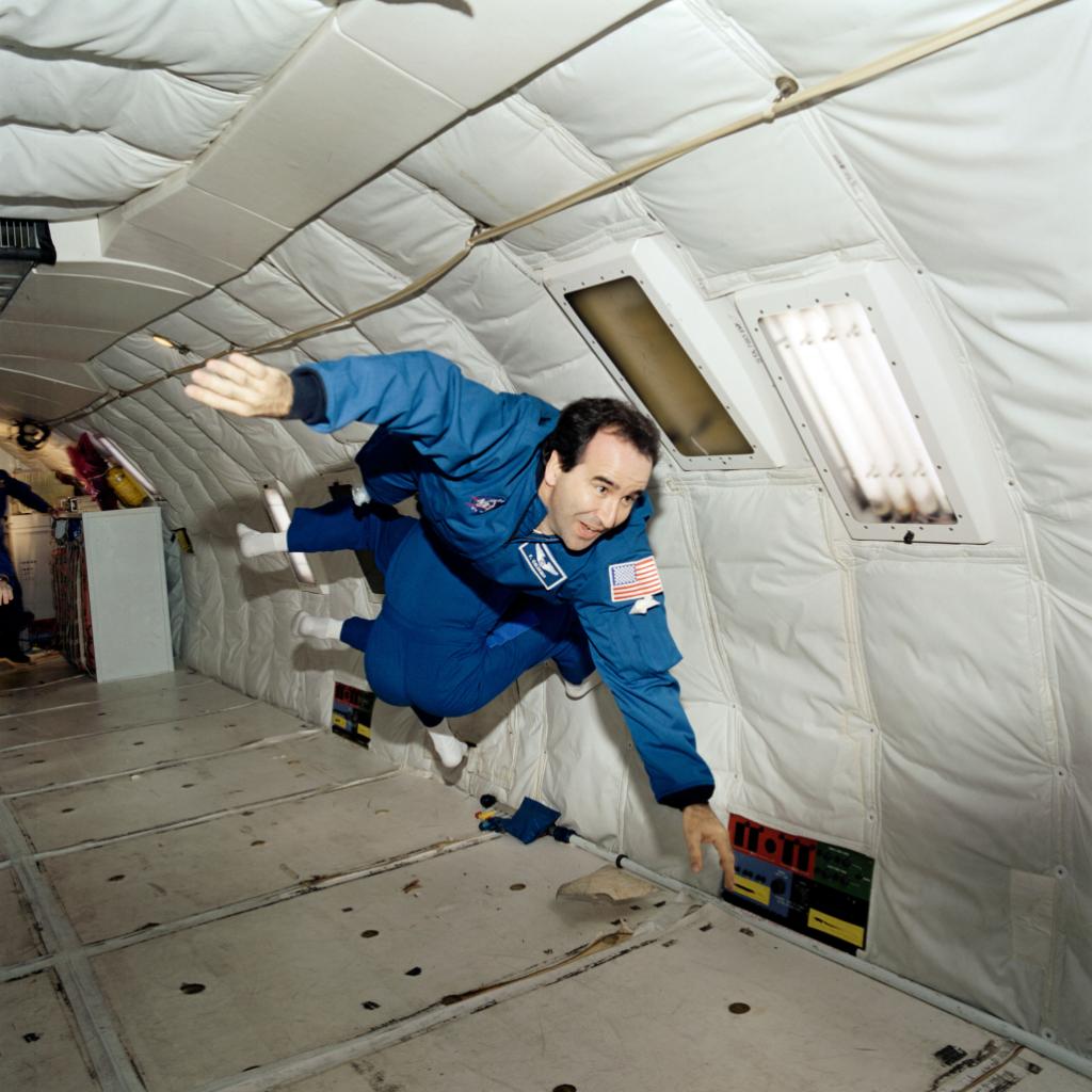 Frank Caldiero floating in simulated zero-gravity in an airplane during ast...
