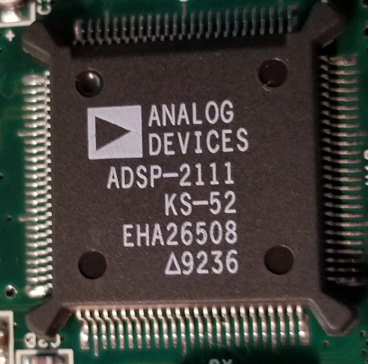 But while we're here, let's figure out what all these chips are.First we've got an Analog Devices ADSP-2111. This is a 16-bit DSP chip.