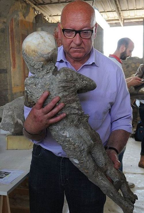 A restorer carries the plaster cast of a child from #Pompeii that perished in the eruption of #MountVesuvius in 79 AD...