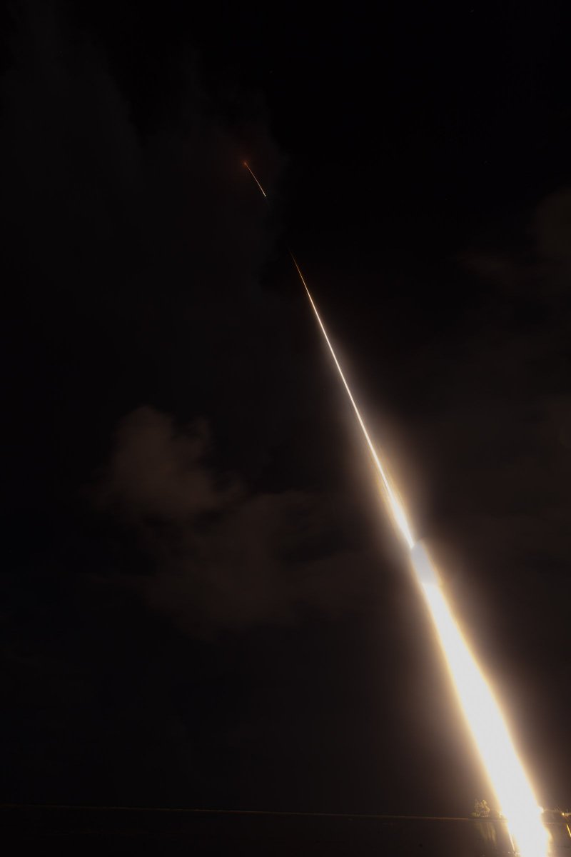 night sky with a long streak of a bright rocket launch