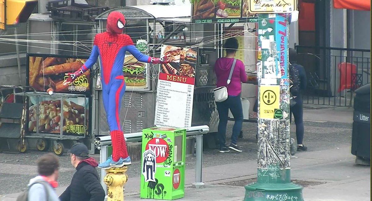TPSOperations's tweet photo. HAZARD:
Spadina Av + Queen St
-Man dressed as spiderman
-Has thrown line/rope over streetcar wires
-Is now 'webbing' off part of the sidewalk
#GO1027674
^dh https://t.co/HyxEPcnTh0