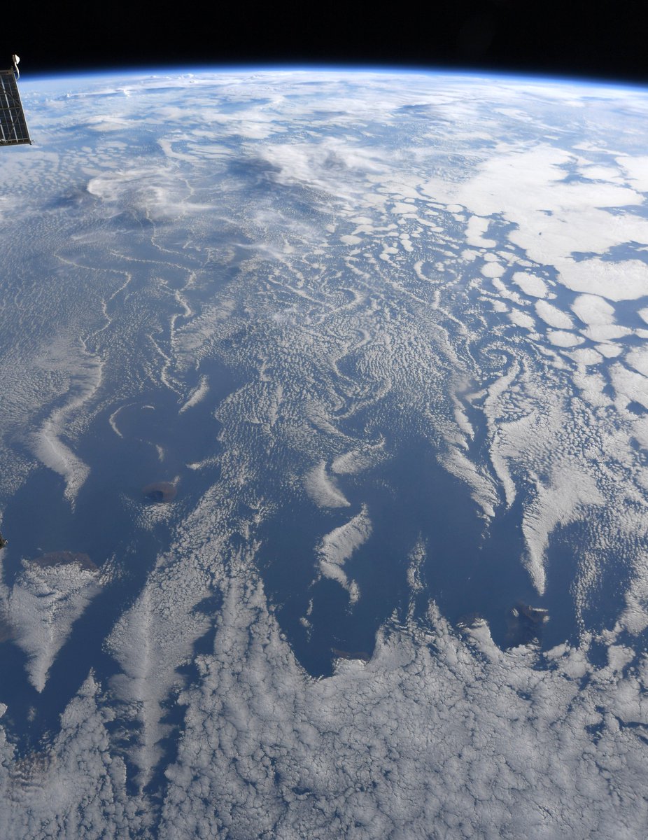 Astro_Christina's tweet photo. Islands off the coast of West Africa, like wing tips cutting through the air, form giant swirling Von Karman vortices showing up in the clouds above. https://t.co/XTq28OYw1U