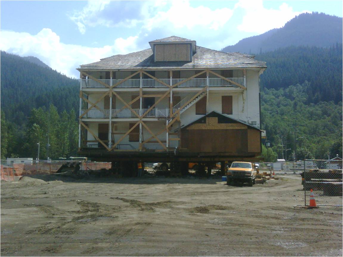 A three story hotel is jacked about six feet off the ground, its windows boarded, its balconies cross braced with lumber.