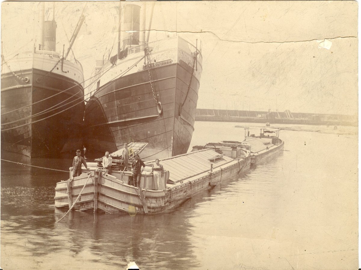 ErieCanalMuseum's tweet photo. #FlashbackFriday This image is titled "Ship to Canal." It's from the late 19th-early 20th century, and shows a Canal cargo boat and its crew next to large ships in Buffalo, New York. Erie Canal Museum collection number 15.04. https://t.co/KYCM1POBml